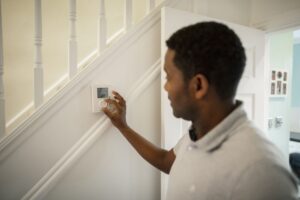 Man Adjusting the Thermostat
